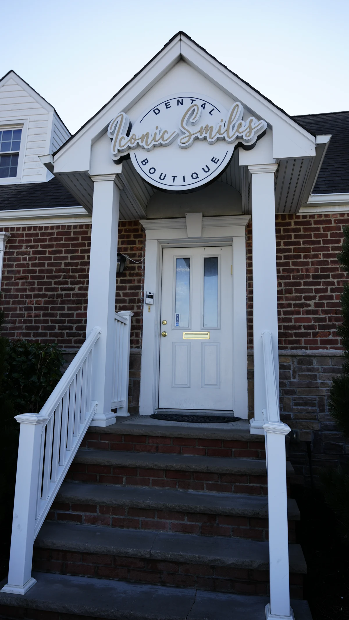 Iconic Smiles sign above the front door and entrance steps of the Bellerose office