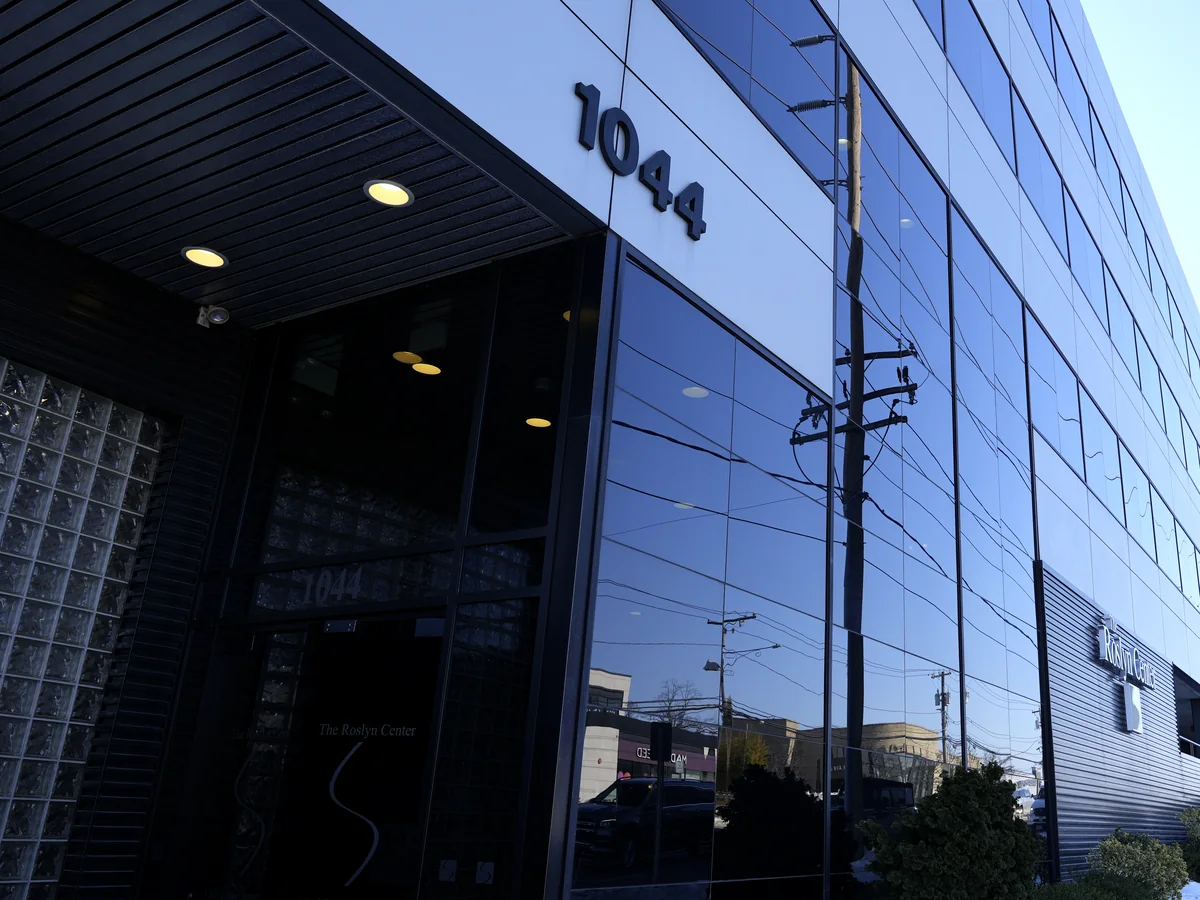Glass entrance of 1044 Northern Blvd in Roslyn, the building that houses the Iconic Smiles office
