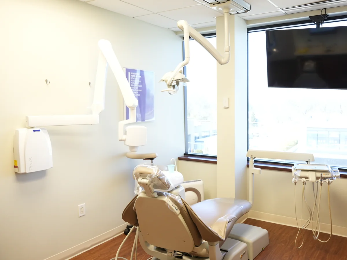 Bright treatment room with a window and a wall screen at the Roslyn office