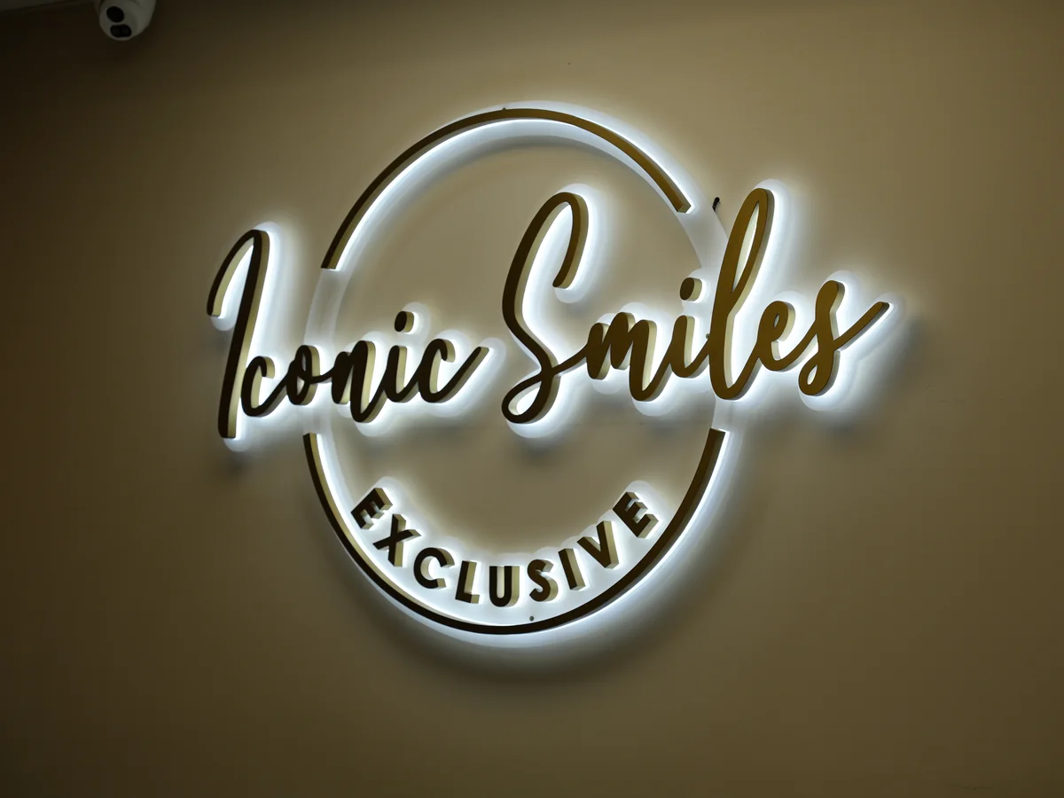 Backlit Iconic Smiles Exclusive sign on the wall at the Roslyn office